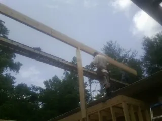 Carpenter setting a ridge beam over a new addition frame — Ice Dam Removal by Roofing Brothers in Jersey City