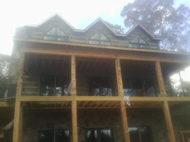 Dormers and porch framing on a large log home under construction — Roof Coating work by our crew in Jersey City