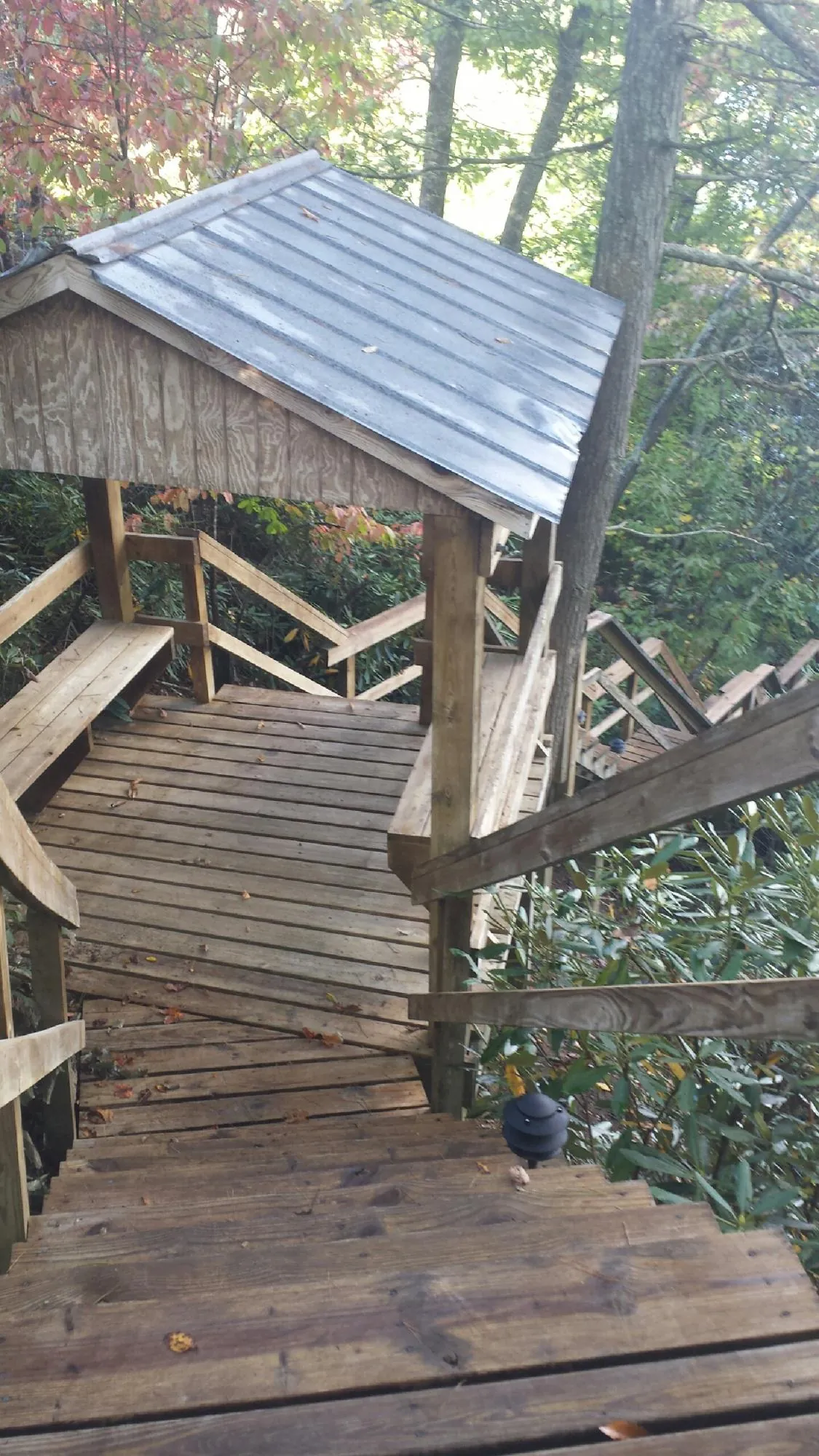 Metal roofed shelter over wooden steps on a wooded walkway — Skylight Repair & Installation work by our crew in Jersey City