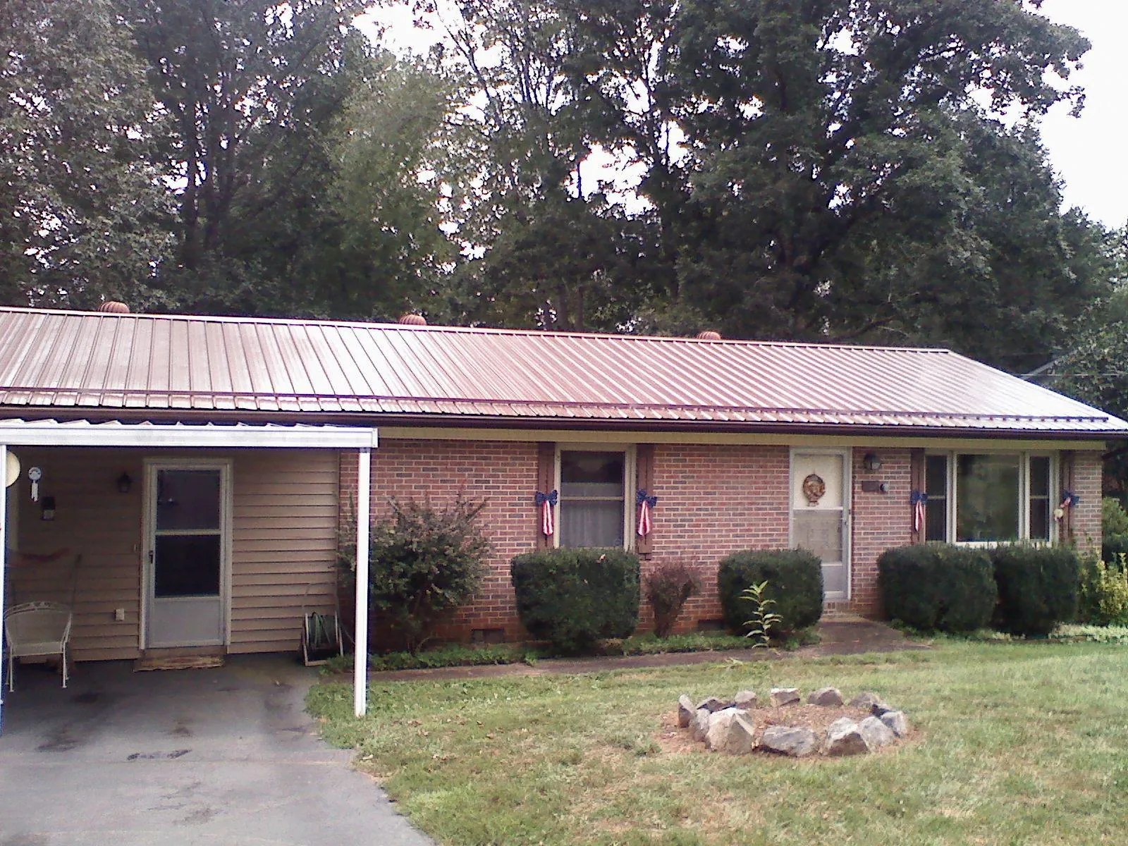 Bronze metal roof and carport on a brick ranch home — Roof Repair work by our crew in Jersey City